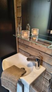 a bathroom sink with a glass shelf above it at Lapelland Village - Riverside Village with a Nature View, Fireplace, Sauna, Kitchen in Äkäslompolo