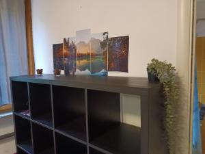 a shelf with three paintings on top of it at Anime Salve B&B E-BIKE HOME RESTAURANT in Sala Baganza