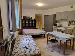 a small kitchen with two beds and a table in a room at Anime Salve B&B E-BIKE HOME RESTAURANT in Sala Baganza