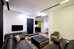 a living room with a couch and a flat screen tv at La Maison De Hamra Hotel Apartments in Beirut
