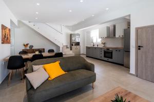 Una sala de estar con un sofá y una cocina. en Rosemary Rhodes Villa, en Malona Village