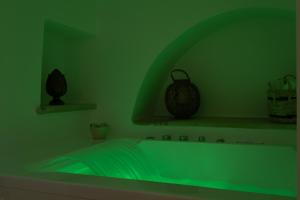 a green bathroom with a tub in a green room at Trulli Suite 34 in Alberobello