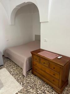 une chambre avec un lit et une commode en bois dans l'établissement Casa Clemence, à Ceglie Messapica