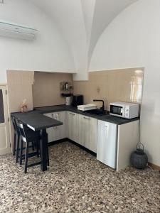 une petite cuisine avec une table et un micro-ondes dans l'établissement Casa Clemence, à Ceglie Messapica