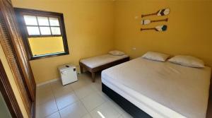 Un dormitorio pequeño con una cama y una ventana. en PeruíBella Pousada, en Peruíbe