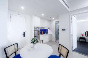 a kitchen and dining room with a white table and chairs at Sole Casa Phu Quoc in Phu Quoc