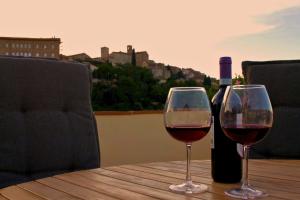 two wine glasses sitting on a table with a bottle of wine at Terrazza Mira - Vista panoramica e parcheggio a Todi in Todi