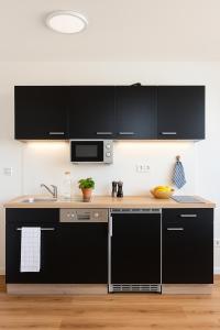 a kitchen with black cabinets and a sink at Dat Fischerhuus in Pruchten +11 photos