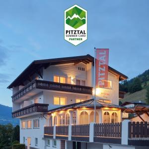 a large building with a sign in front of it at Pitztal Living Apartments in Jerzens