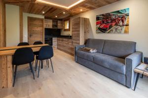 a living room with a couch and a table and chairs at Ermitage 28 in Méribel