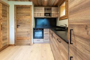 a kitchen with wooden cabinets and a wooden door at Ermitage 28 in Méribel