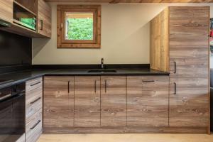 a kitchen with wooden cabinets and a sink at Ermitage 28 in Méribel