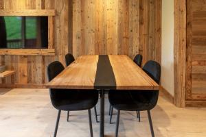 a wooden table with black chairs around it at Ermitage 28 in Méribel