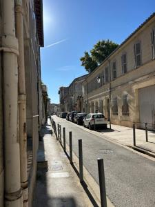 a street with cars parked on the side of the road at Appartement Intra-muros in Avignon +7 photos