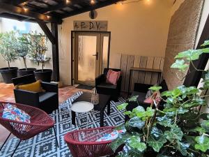 a living room with chairs and tables and plants at Gîte Au Pied Des Vignes in Wettolsheim