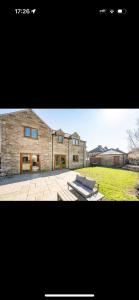 a large brick house with a patio in front of it at Willow falls in Wortley