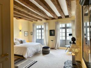 a bedroom with a bed and some windows at Auberge Radieuse in Azay-le-Rideau