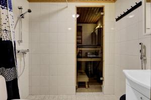 a bathroom with a shower and a sink at Villa Tundra - Valkea Homes in Pyhätunturi