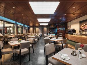 a restaurant with wooden ceilings and tables and chairs at Hotel Andreas Hofer in Kufstein