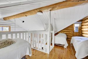 a bedroom with two beds in a log cabin at Villa Tundra - Valkea Homes in Pyhätunturi