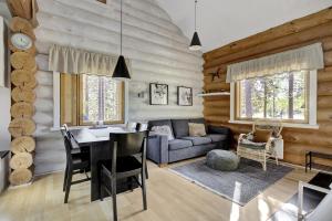 a living room with a table and a couch at Villa Tundra - Valkea Homes in Pyhätunturi