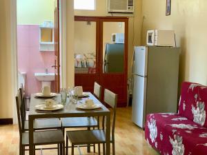 a dining room with a table and a refrigerator at Treetops Studios Valencia, Dumaguete in Valencia