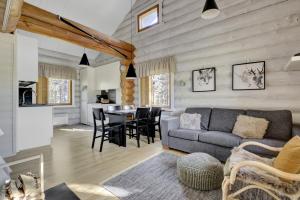 a living room with a couch and a table at Villa Tundra - Valkea Homes in Pyhätunturi +27 photos