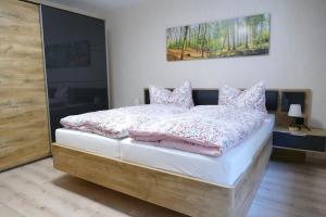 a bedroom with a bed with pink pillows at Silvias Ferienwohnung - Bohlweg 43 in Wildemann