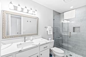 ein Badezimmer mit Waschbecken, Toilette und Spiegel in der Unterkunft Beach Club Villa 32 - Newly Renovated! Direct Oceanfront in Isle of Palms + 28 Fotos