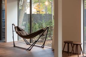 a hammock sitting in a room next to a window at Mori no Hanare in Karuizawa