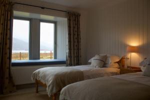 une chambre d'hôtel avec deux lits et une fenêtre dans l'établissement Torran Cottage, à Achnashellach Station