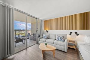 a living room with a couch and a table at Waikiki 30FL Luxury Studio with Majestic Ocean Fireworks in Honolulu +50 photos
