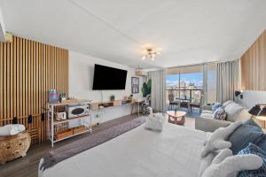 a living room with a couch and a flat screen tv at Waikiki 30FL Luxury Studio with Majestic Ocean Fireworks in Honolulu