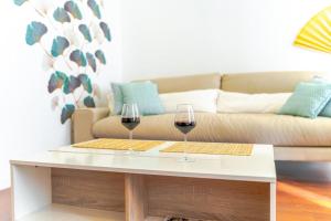 two glasses of wine on a coffee table in front of a couch at Expoholidays- Rueda Lopez con PARKING GRATIS 3A in Almería +13 photos