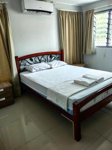 a bedroom with a bed with white sheets and a window at Pacific FairPrice Private room, shared kitchen in Nadi