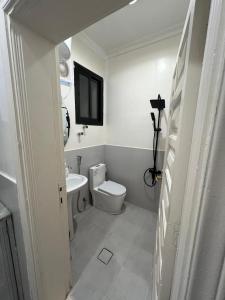 a bathroom with a toilet and a tv on the wall at شقة خاصة من غرفتين قريبة من المسجد النبوي in Al Madinah