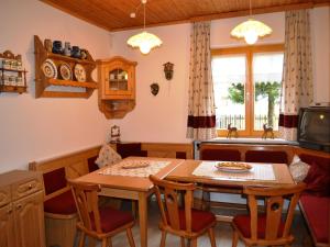 a kitchen and dining room with a table and chairs at Renovated Mountain Retreat Stay in Pruggern