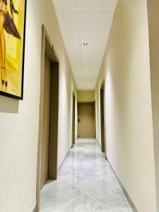 a hallway with white walls and a painting on the wall at Hotel Balaji Inn, Ayodhya Bypass in Bhopal +24 photos