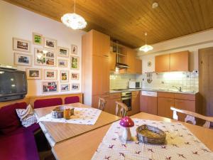 a kitchen with a table and a dining room at Renovated Mountain Retreat Stay in Pruggern