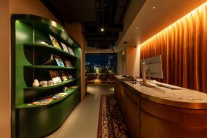 a room with a desk with a green shelf at &Here SHINJUKU in Tokyo