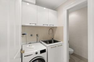 a small bathroom with a sink and a washing machine at Beautiful Terrace Home with Courtyard in Wickham +8 photos