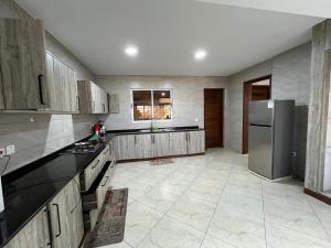 a kitchen with wooden cabinets and a stainless steel refrigerator at Antalya Epic stays in Mombasa +8 photos