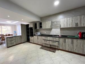 a large kitchen with wooden cabinets and a table at Antalya Epic stays in Mombasa