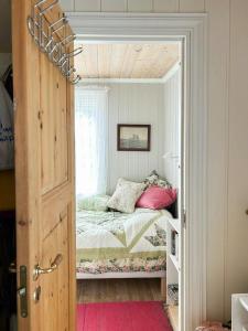 ein kleines Schlafzimmer mit einem Bett mit Fenster in der Unterkunft Cabin With Sea View Near Risør in Søndeled + 32 Fotos