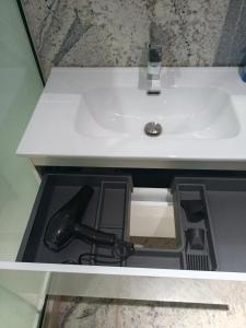 a sink in a bathroom with a black pipe under it at The Iconic Place in Garki +3 photos