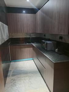 a kitchen with wooden cabinets and a microwave on a counter at The Iconic Place in Garki