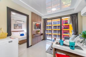 a hotel room with a bed and a dining table at SOLA Condo 1BR Tropical View NBC Nai Harn Nai in Rawai Beach