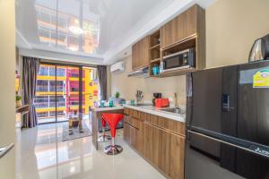 a kitchen with a red stool in the middle of it at SOLA Condo 1BR Tropical View NBC Nai Harn Nai in Rawai Beach +18 photos
