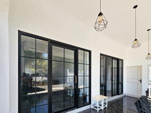 a living room with black windows and a white wall at Dhoriz Homestay Syariah RedPartner at Kampung Inggris Pare in Pare