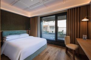 a bedroom with a bed and a desk and a window at Changbai Mountain Lanpu Design Hotel in Antu